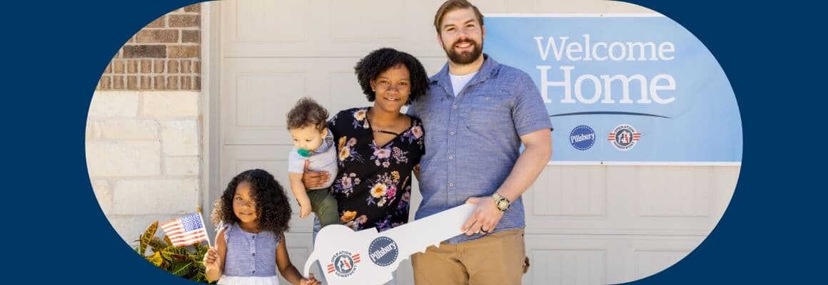   A happy family of four stands in front of their new home. A welcome home banner is visible behind them, featuring the Pillsbury and Operation Homefront logos. The family includes a father, mother, daughter, and baby son. The parents are smiling broadly, and the children look content. The scene conveys a sense of joy and accomplishment.