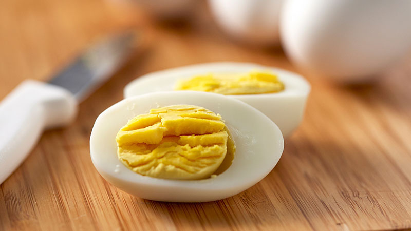 Sliced hard boiled egg with a knife